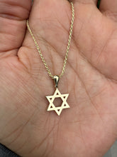 Load image into Gallery viewer, Willow Row-14K Gold flat Star of David charm hanging on a rope chain featured on a hand
